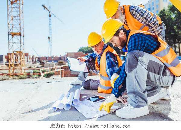 建筑工人穿着制服坐在混凝土在施工现场讨论建设计划辛苦工作